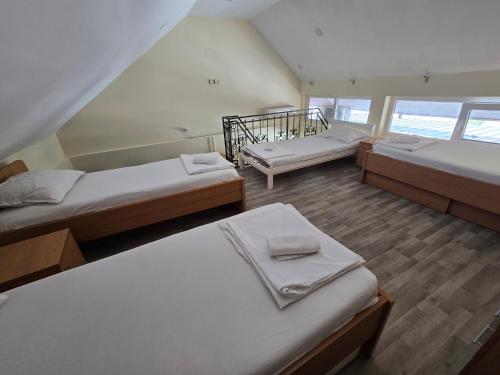 a room with three beds and a staircase at Apartman Galerija in Užice