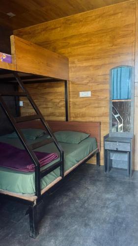 a bedroom with a bunk bed and a mirror at Apm resort kodai in Kodaikānāl