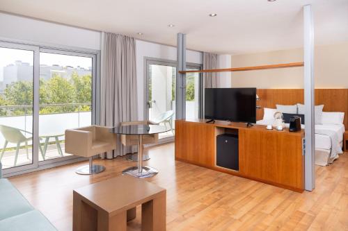 a hotel room with a bed and a flat screen tv at RVHotels Nautic Park in Platja d'Aro