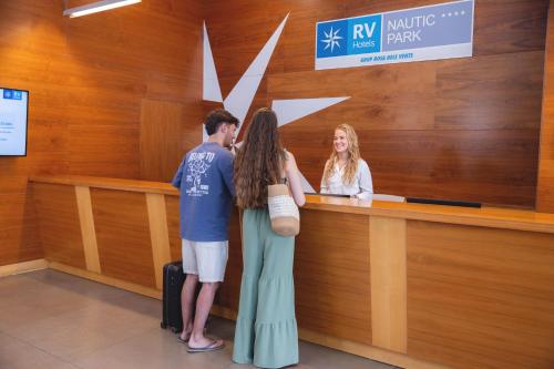 a man and a woman standing at a cash register at RVHotels Nautic Park in Platja d'Aro