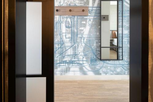 a glass door with a drawing on the wall at Moxy Portland Thompson's Point in Portland