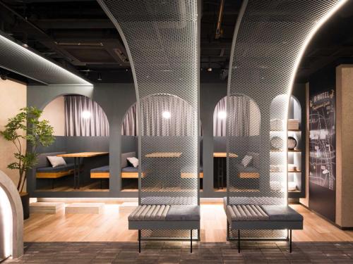 a room with two benches in front of a table at R Hotel Nagoya Station in Nagoya