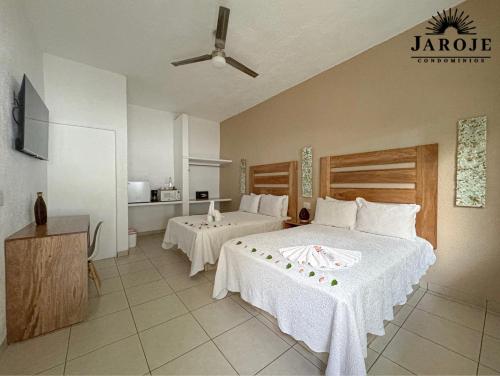 ein Hotelzimmer mit zwei Betten und einer Küche in der Unterkunft Condominios JAROJE Huatulco in Santa Cruz Huatulco