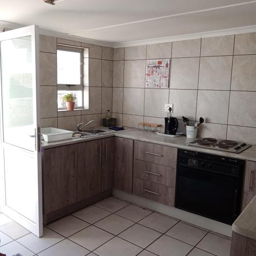 a kitchen with a sink and a stove at Arniston Cottage in Arniston