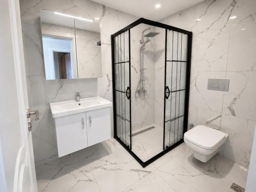 a bathroom with a shower and a toilet and a sink at Bodrum Blue Bay Hotel & Restaurant in Bodrum City