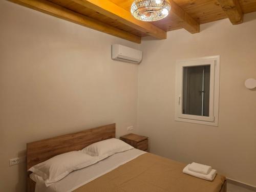 a bedroom with a bed and a window at Sun & Stones Suite in Agrari