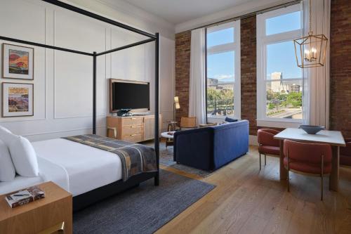 a bedroom with a bed and a desk and a television at Asher Adams, Autograph Collection in Salt Lake City