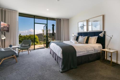 a bedroom with a large bed and a large window at Blue Range Estate Villas in Rosebud