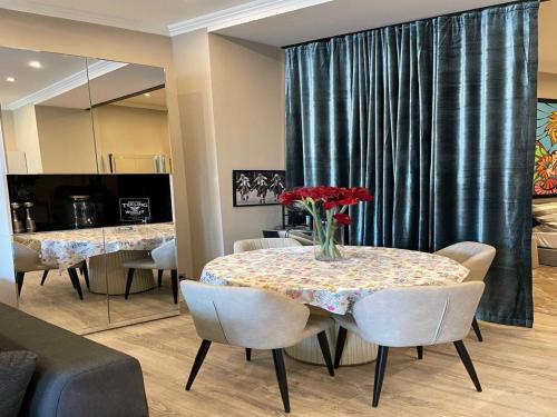 a dining room with a table with a vase of flowers on it at Modern Suite in the Taunus in Bad Camberg