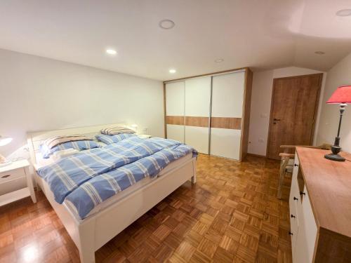 a bedroom with a bed and a desk with a lamp at Apartma AURA in Slovenske Konjice