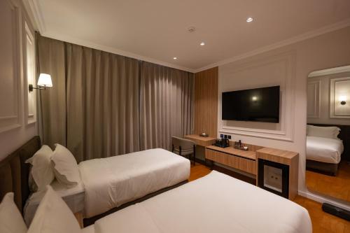 a hotel room with two beds and a flat screen tv at Hotel By Holiday in Rinas