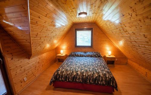 a bedroom with a large bed in a wooden room at Chata Huta in Muránska Huta