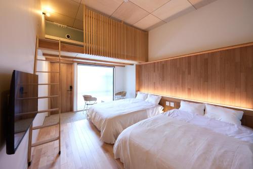 a hotel room with two beds and a window at nedoko in Sumoto