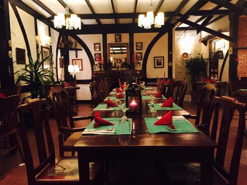 a long wooden table in a restaurant with red napkins at The Bala's Holiday Chalet in Cameron Highlands