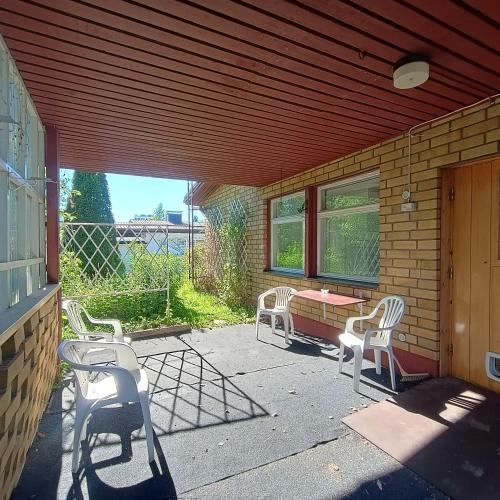 a patio with three chairs and a table and a building at Villa Aspen in Kokkola