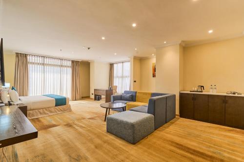 a hotel room with a bed and a kitchen at Best Western Premier Dynasty in Addis Ababa