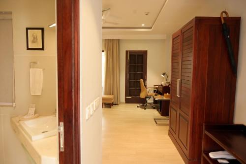 a room with a bathroom with a sink and a desk at Zone Niathu Dimapur By The Park in Dimāpur