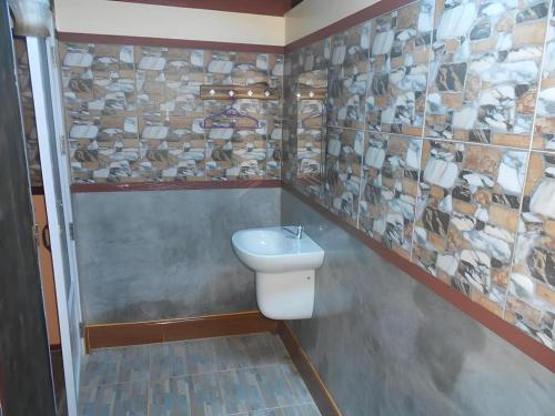 a bathroom with a toilet and a stone wall at Na Chan Resort in Ban Khlong Khlung (1)