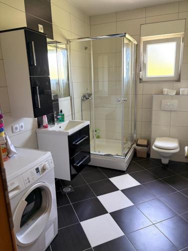 a bathroom with a shower sink and a washing machine at Sobe DANA Banja Vrućica in Teslić