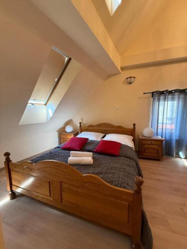 a bedroom with a large wooden bed with red pillows at Willa przy Czarnej Bramie in Kłodzko