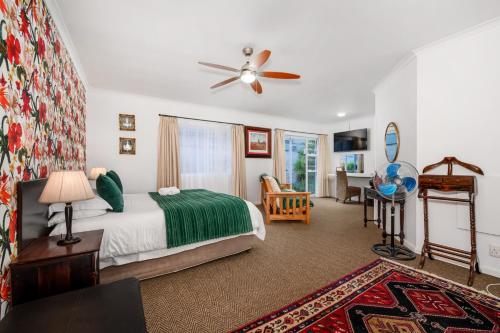 a bedroom with a bed and a ceiling fan at Abalone Guest House in Port Elizabeth