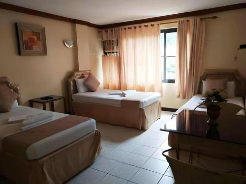 a hotel room with two beds and a couch at Splash Mountain Resort & Hotel in Forestry