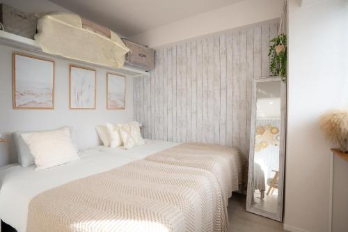 a white bedroom with a bed and a mirror at Ocean Front! New Built Apartment! SOU Resort YAKA in Kin