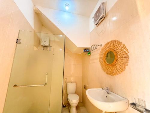a bathroom with a sink and a toilet and a mirror at Emka Family Villa Malang in Malang