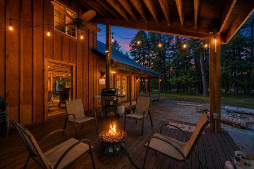 a deck with chairs and a fire pit on a cabin at Pine Acres by NW Comfy Cabins in Leavenworth