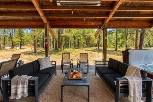 a patio with couches and a table and chairs at Pine Acres by NW Comfy Cabins in Leavenworth