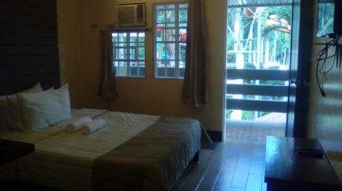 a bedroom with a bed in a room with windows at Pineapple Island Resort in Badas