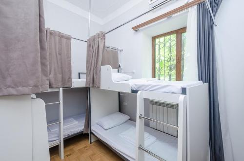 a room with two bunk beds and a mirror at Garden Hostel 16 in Yerevan