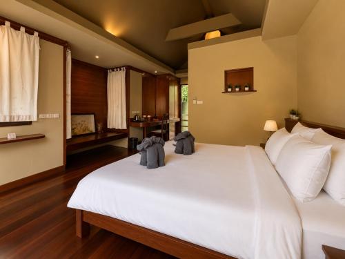 a bedroom with a large white bed with two bags on it at Flow Hua Hin - Ice Bath and Villa in Hua Hin