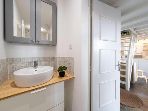 a bathroom with a white sink and a door at Parenthèse en Ville in Arcachon