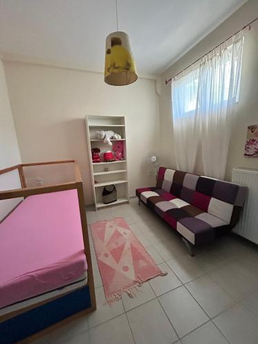 a room with a bed and a couch in it at Sunset View Maisonette, Kanali in Néa Thésis