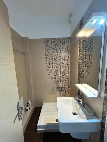 a white bathroom with a sink and a mirror at Sunset View Maisonette, Kanali in Néa Thésis