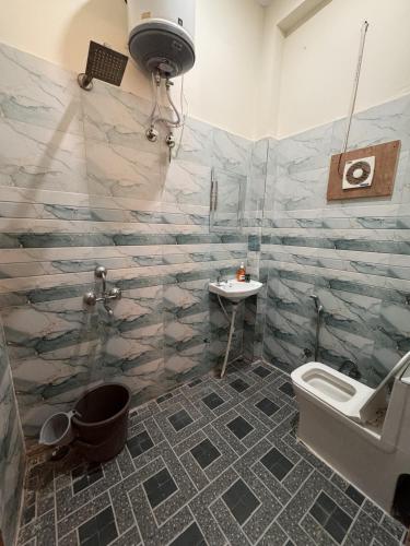 a bathroom with a toilet and a sink at Ashirwad Stay in Rishīkesh