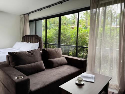 a living room with a couch and a large window at Aranya Bliss Villa 105 in Ban Madua Wan
