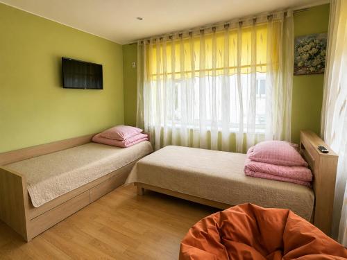 a bedroom with two twin beds and a window at Venta City Apartment in Venta