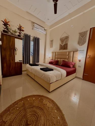 a bedroom with a large bed with red pillows at Ashirwad Stay in Rishīkesh