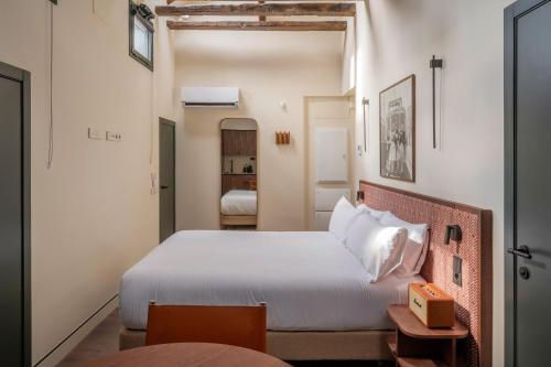 a bedroom with a bed and a room with two beds at POSTCODE Chueca in Madrid