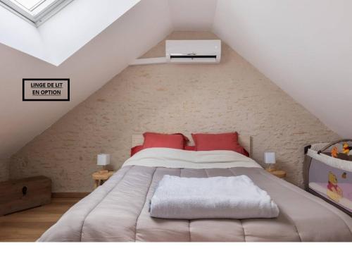 a bedroom with a large bed in a attic at Gîte Le Clos Controis in Le Controis En Sologne