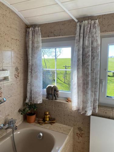 a bathroom with a tub and a window with an elephant statue at Apartment with a view in Upflamör in Zwiefalten