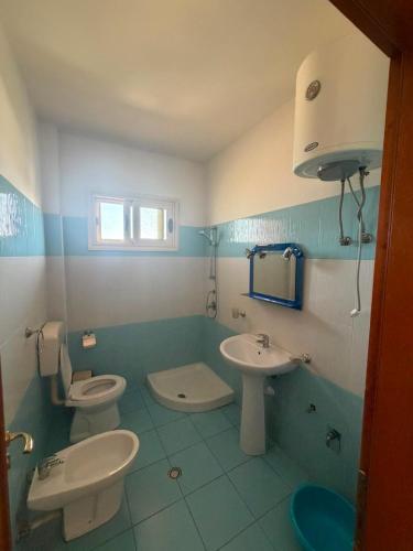 a bathroom with two toilets and a sink at A&A Aparthotel in Orikum