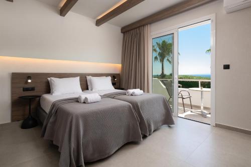 a bedroom with a bed with a view of the ocean at Sam's Faliraki in Faliraki