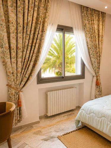 a bedroom with a bed and a window at Chez Roberto in La Marsa