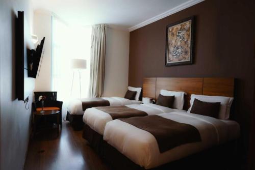 a hotel room with two beds and a window at Elaf Almaqamah Nour Althuria Hotel in Mecca