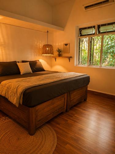 a bedroom with a large bed and a window at Villa Pont Bleu in Canacona
