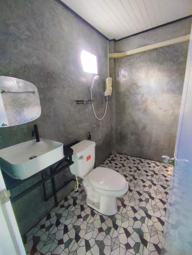 a bathroom with a white toilet and a sink at Good View Guest House in Phatthalung