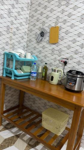 a wooden table with a coffee maker on top of it at The Cozy Nest in Tanga
